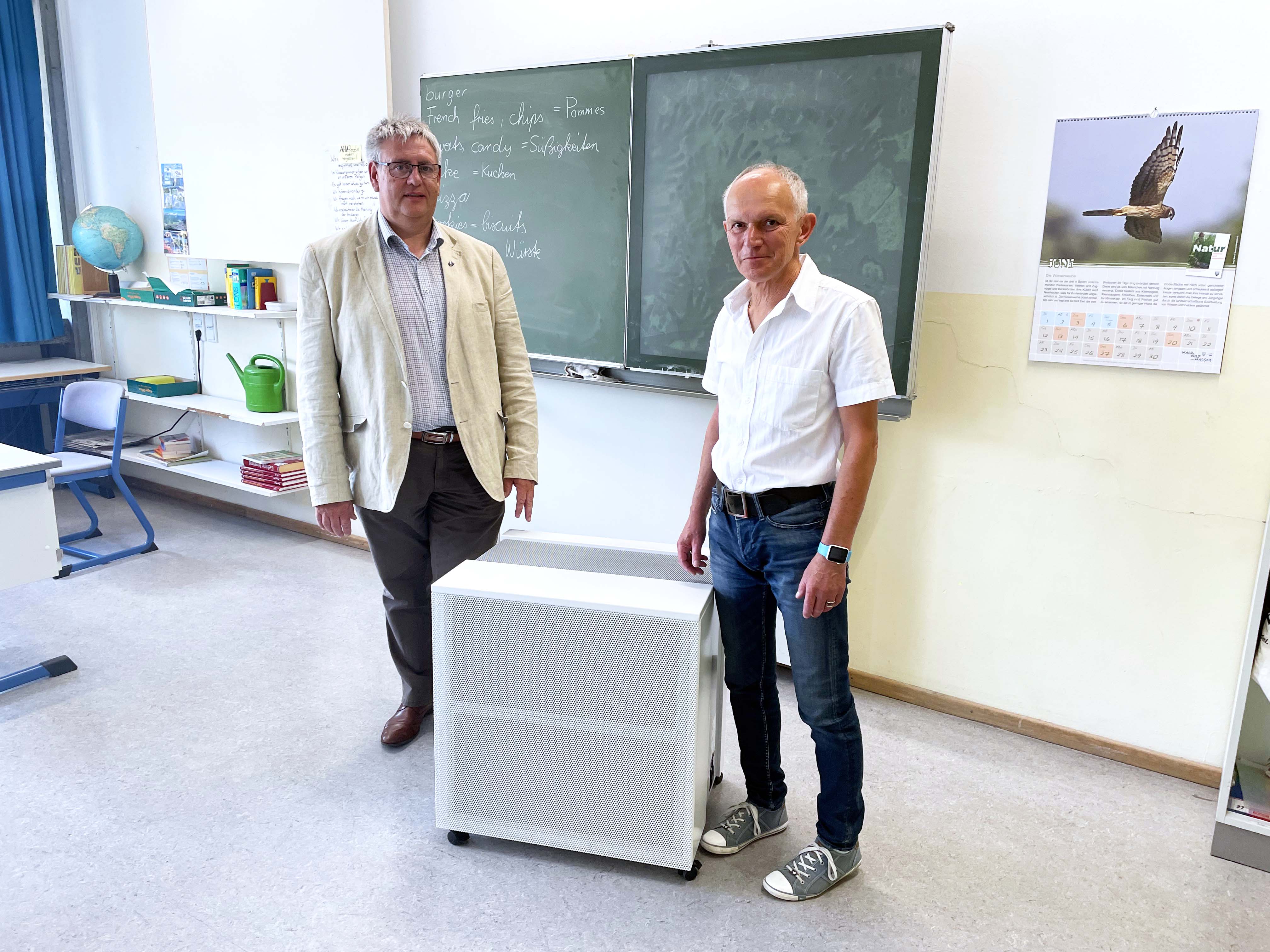 Foto: Bürgermeister Herbert Tischhöfer (links) und Schulleiter Dr. Erwin Geitner (rechts) sind froh, dass bereits alle Klassenzimmer in den Schulen am Mönchsberg seit Dezember 2020 über Luftfiltergeräte verfügen.