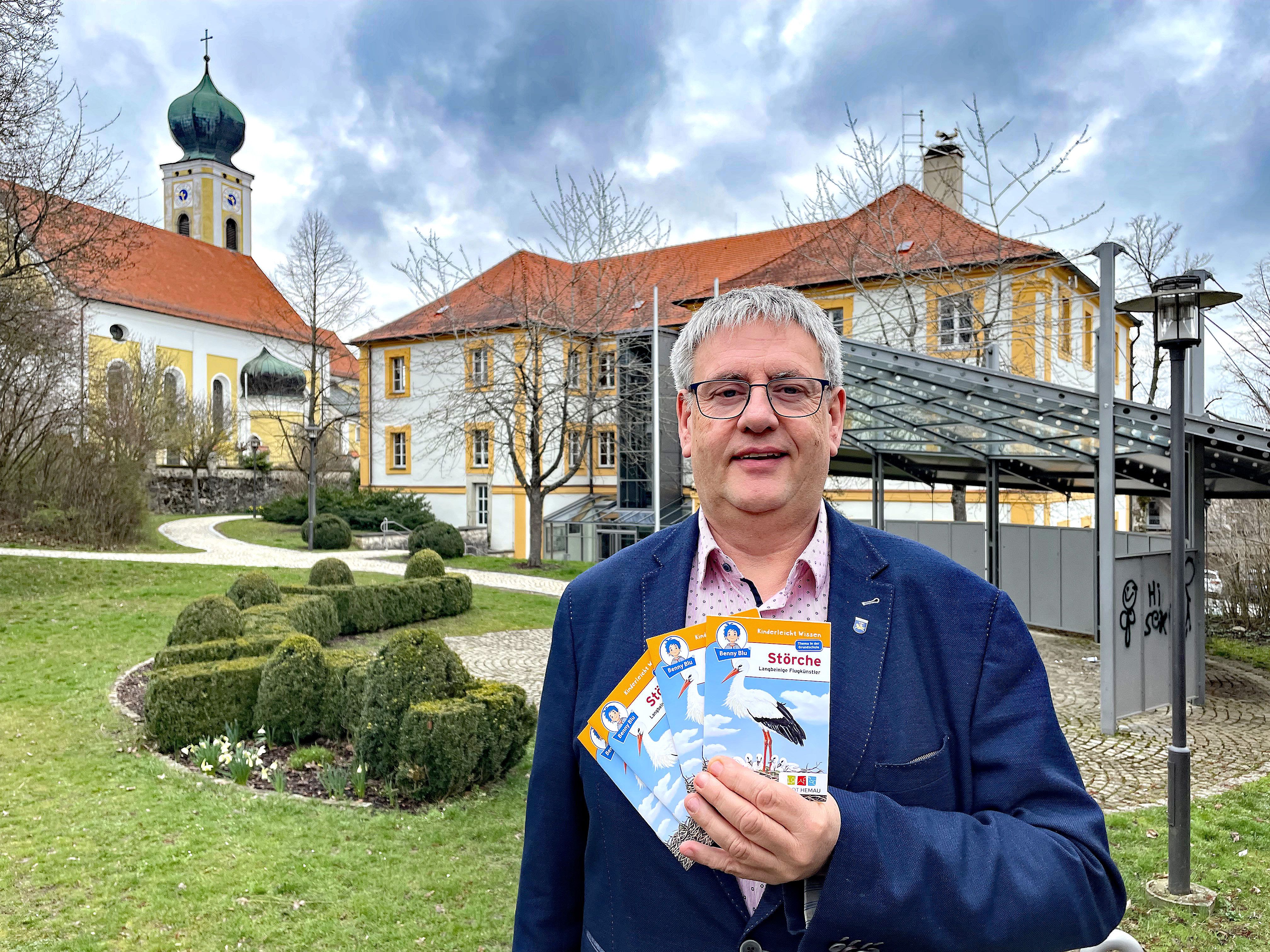 Premiere: Bürgermeister Herbert Tischhöfer präsentiert das erste eigene Kinderbuch der Stadt Hemau. Im Hin-tergrund das Storchenpaar auf dem Rathausdach.